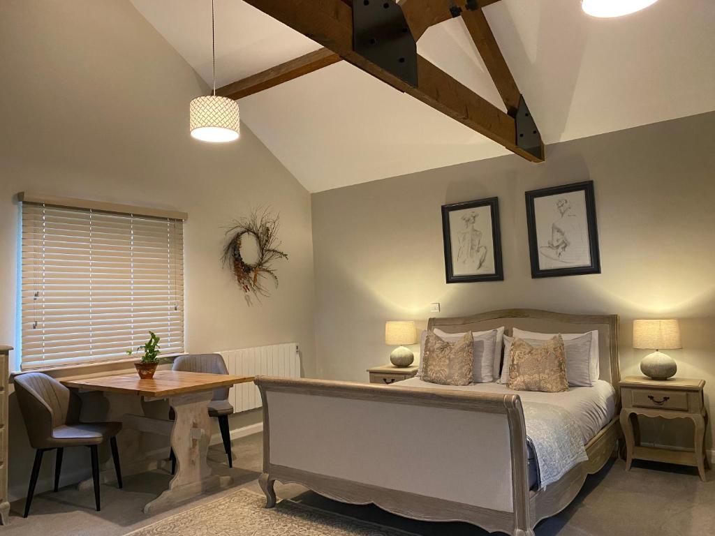 een slaapkamer met een bed, een bureau en een tafel bij White House Farm - Beautiful Self Contained Courtyard Rooms in Whitby