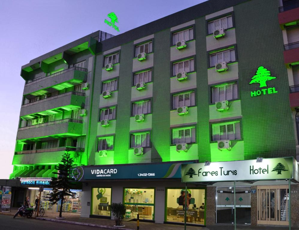 un hotel con luces verdes en la parte delantera en Fares Turis Hotel en Uruguaiana