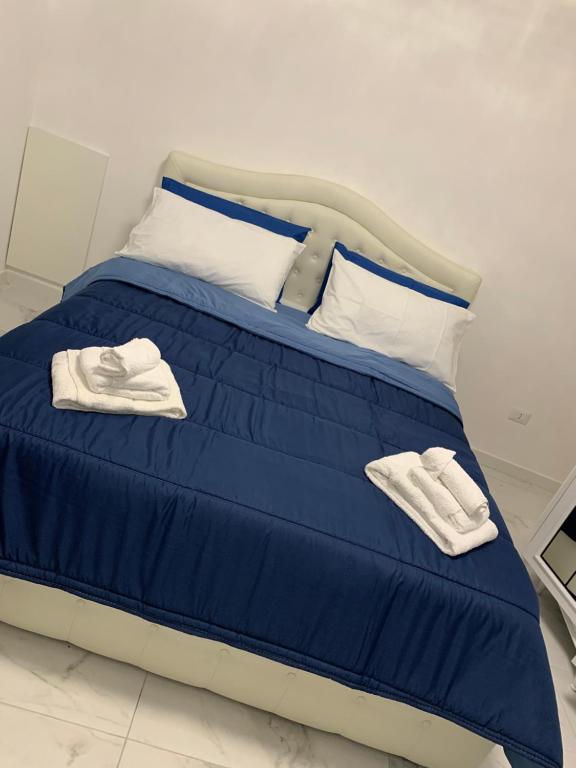 Una cama con sábanas azules y toallas blancas. en A cas e Nanninell, en Nápoles