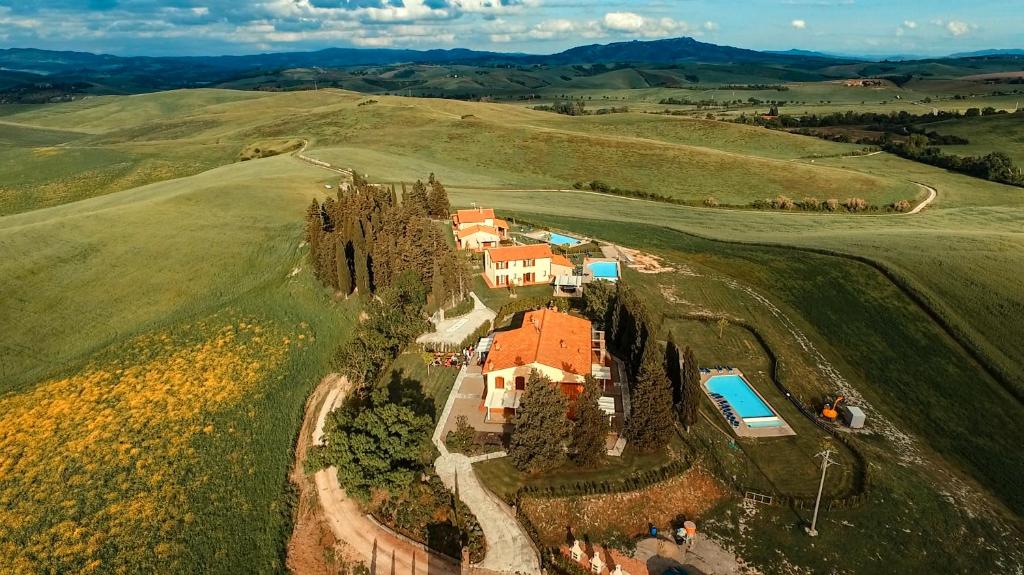 una vista aerea di una casa in un campo di Borgo del Silenzio - Apartments with pool in Lajatico a Laiatico
