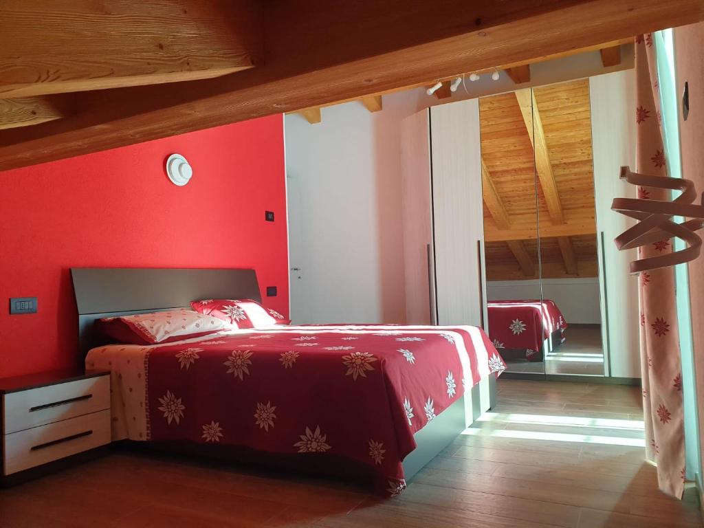 a bedroom with red walls and a bed with red sheets at Casa Vacanza Lo Nânò in Fenis