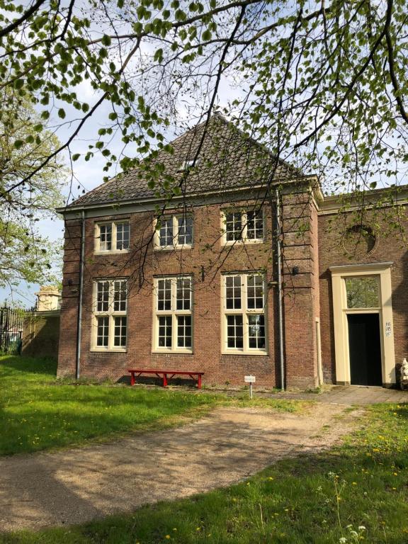 un gran edificio de ladrillo con una gran ventana en Monumental villa at the forest close to Haarlem and the beach, en Heemstede