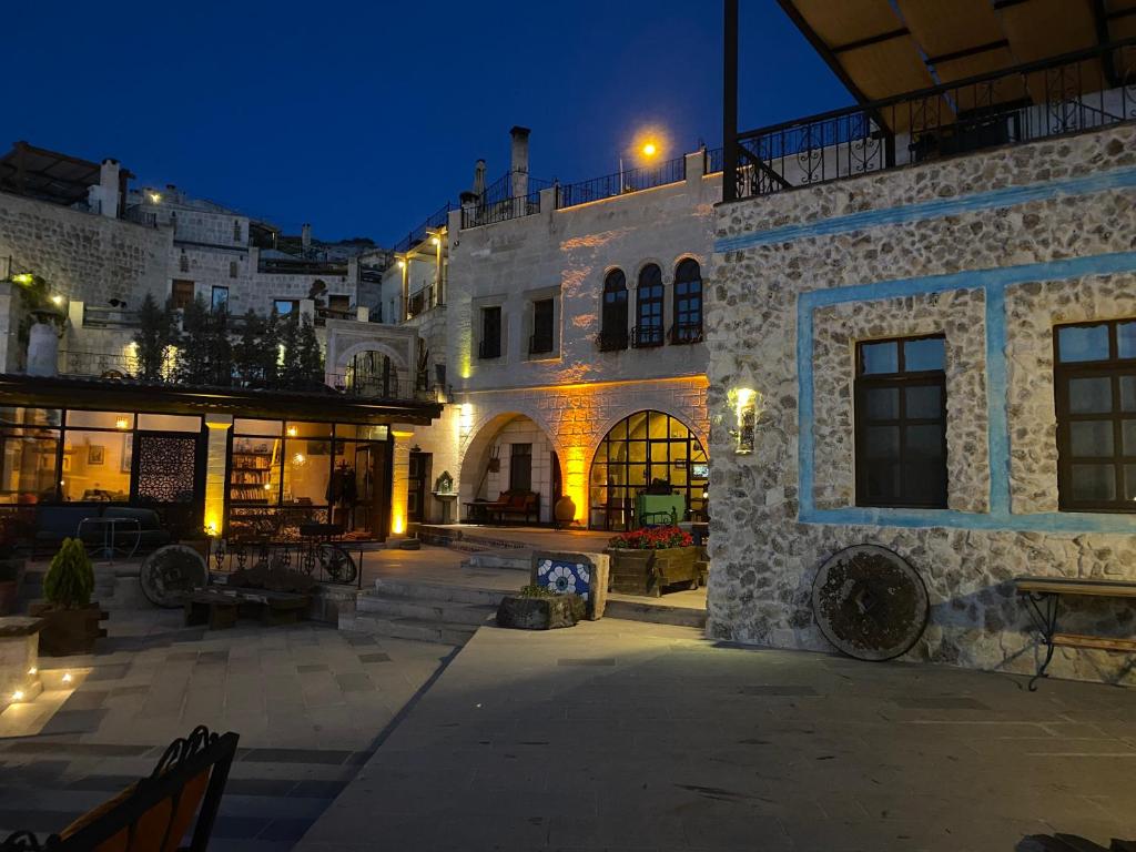 een groot stenen gebouw met een patio in de nacht bij Canela Cave Hotel - Cappadocia in Goreme