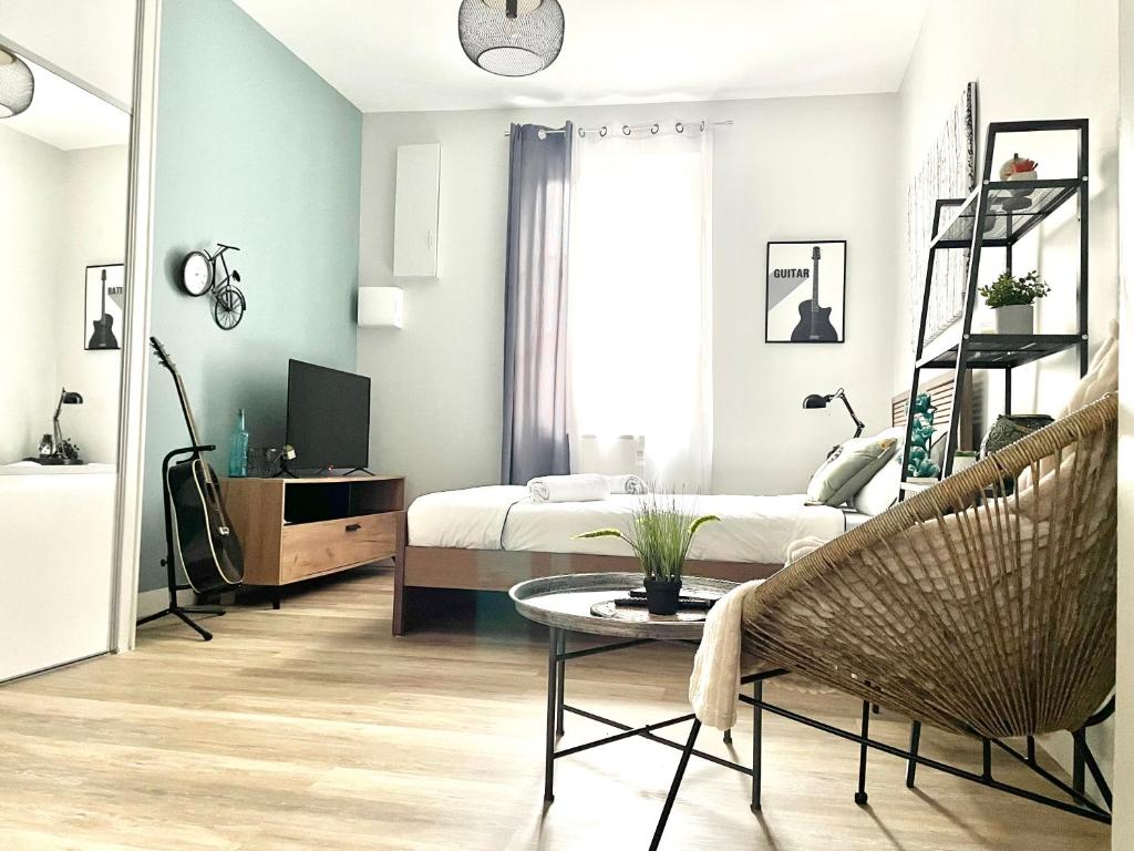 a bedroom with a bed and a table and a chair at Arina & Julien Dieppe in Dieppe