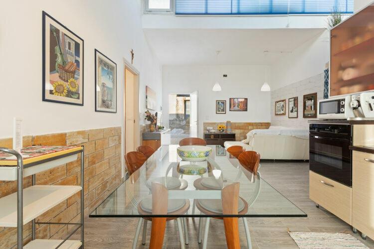 uma cozinha e sala de estar com uma mesa de vidro em Blu Corallo Villa em Alcamo