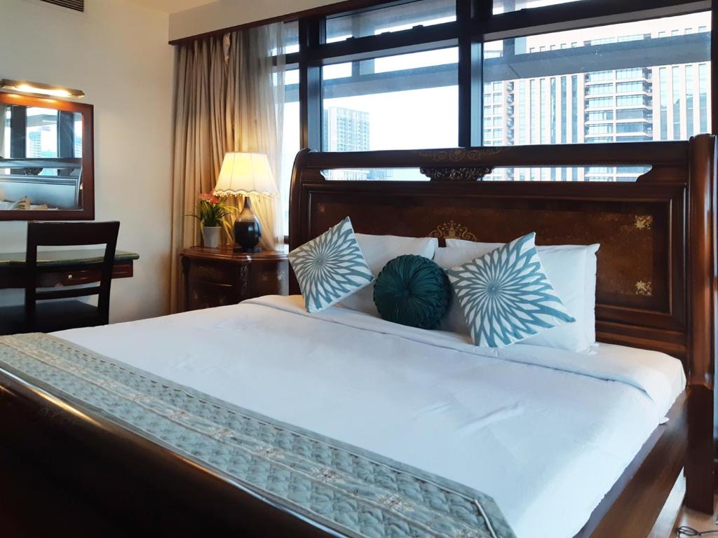 a bedroom with a large bed with blue and white pillows at Comfort Service Apartment at Times Square KL in Kuala Lumpur