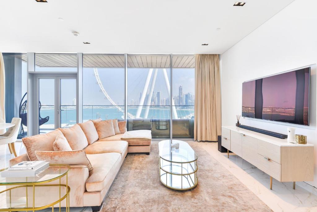 a living room with a couch and a tv at Island Paradise - Stylish 2BR on Bluewaters Island in Dubai