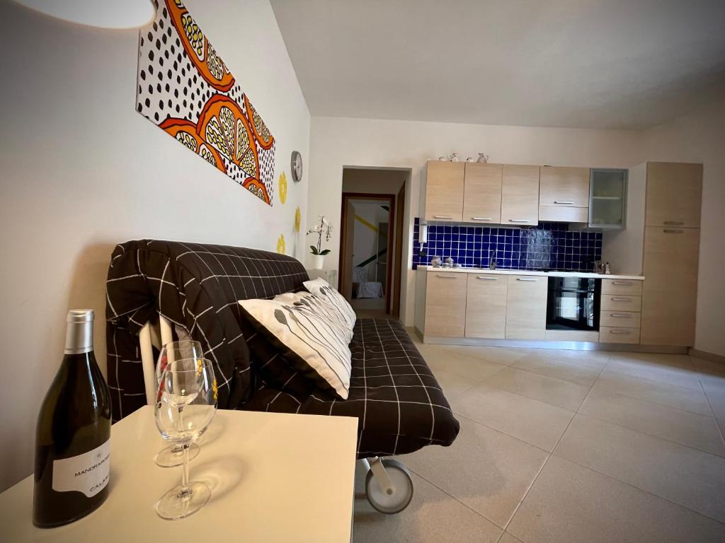 a living room with a couch and a bottle of wine at Casa Serra in Porto Palo
