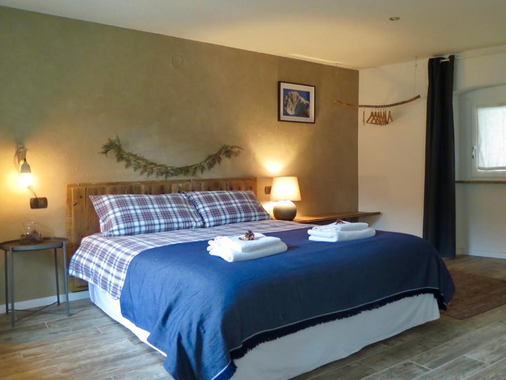 a bedroom with a bed with two towels on it at Maison de la montagne - Chambres & Relax in Arvier