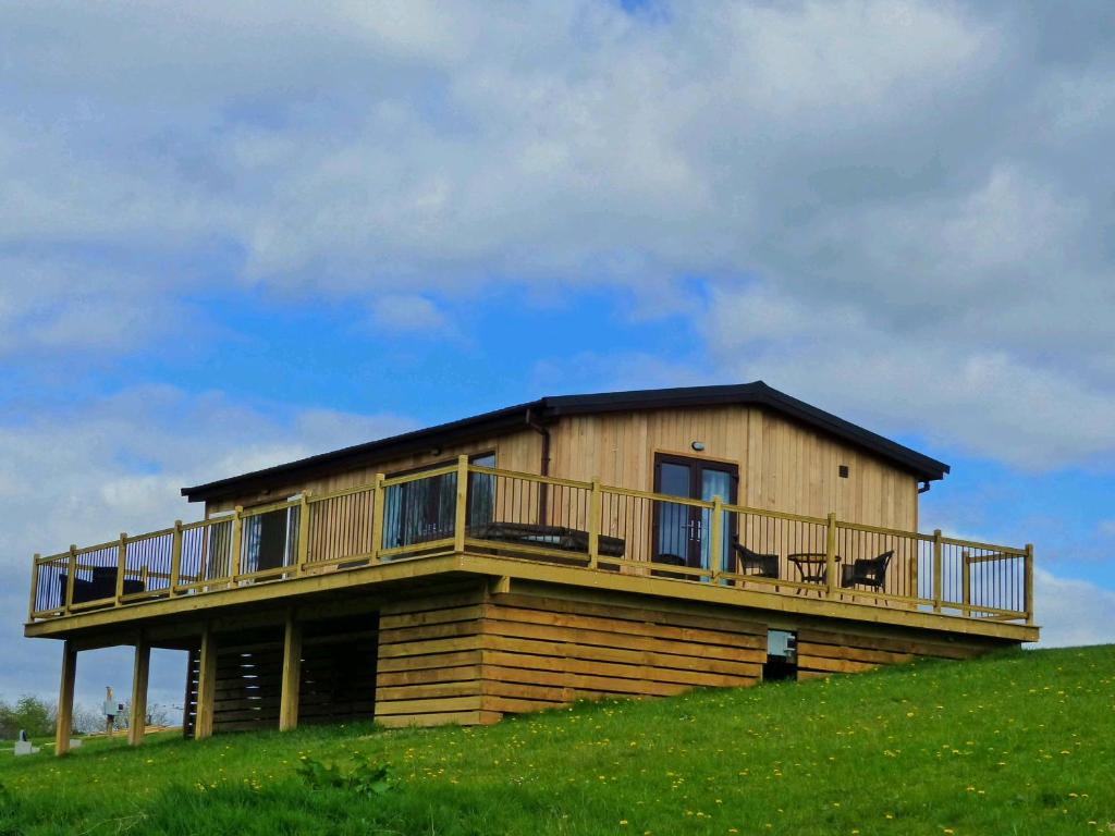 a house on top of a hill with a deck at Shropshire Lodges - Romantic Luxury Hot Tub Breaks in Bridgnorth