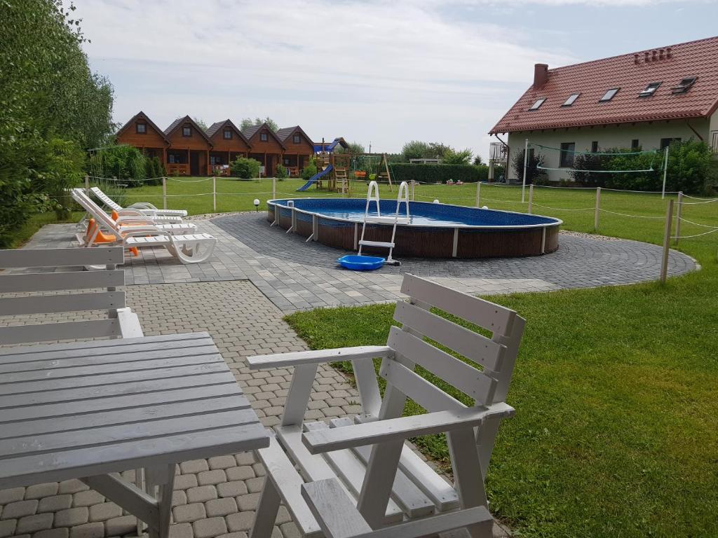 un parque con 2 bancos y una piscina en Domki Morskie Opowieści en Nickelswalde
