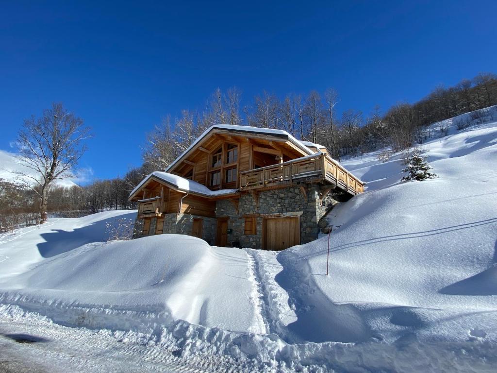 una baita di tronchi nella neve con molta neve di mini duplex dans chalet a Saint-François-Longchamp