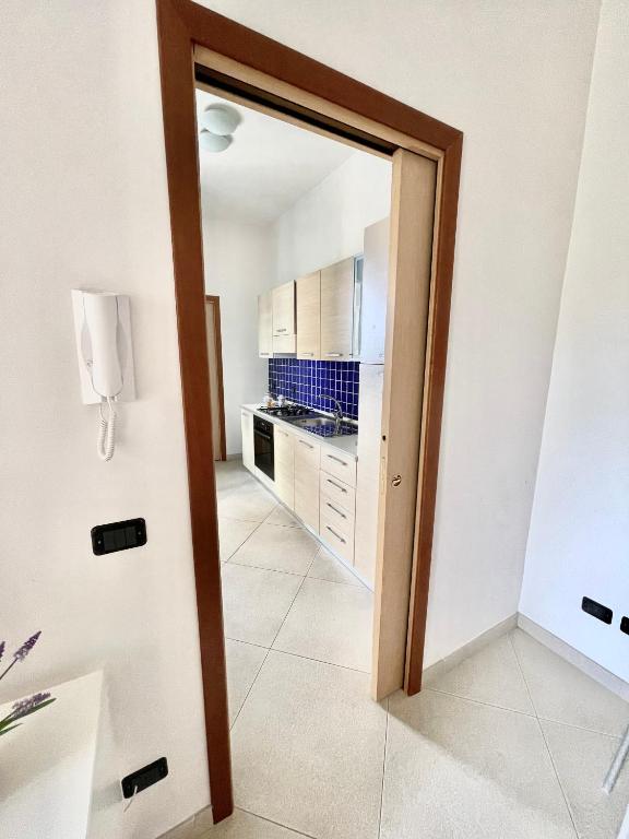 a door leading to a kitchen with white cabinets at Casa Serra in Porto Palo