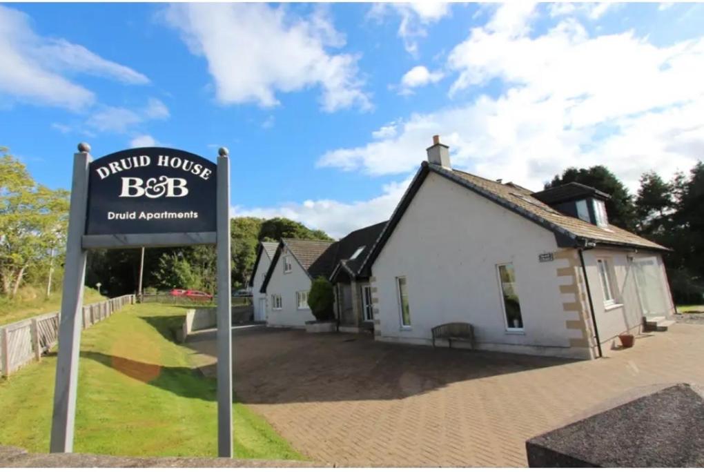 una señal frente a una casa blanca en Druid House B&B en Inverness