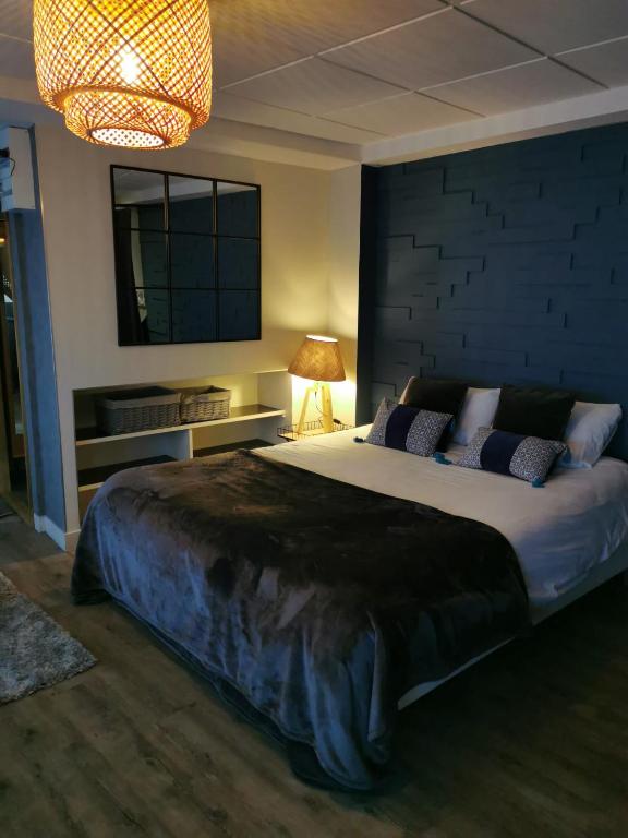 une chambre avec un grand lit et une lampe dans l'établissement Au Saint Martin 2, à Cholet