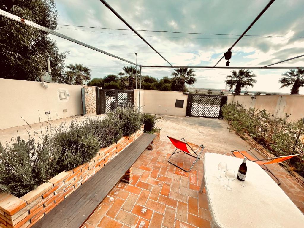 a patio with a table and chairs and plants at Casa Serra in Porto Palo