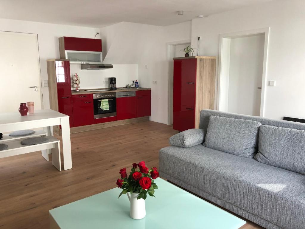 a living room with a couch and a table with flowers at FeWo am Markt Wipperfürth in Wipperfürth