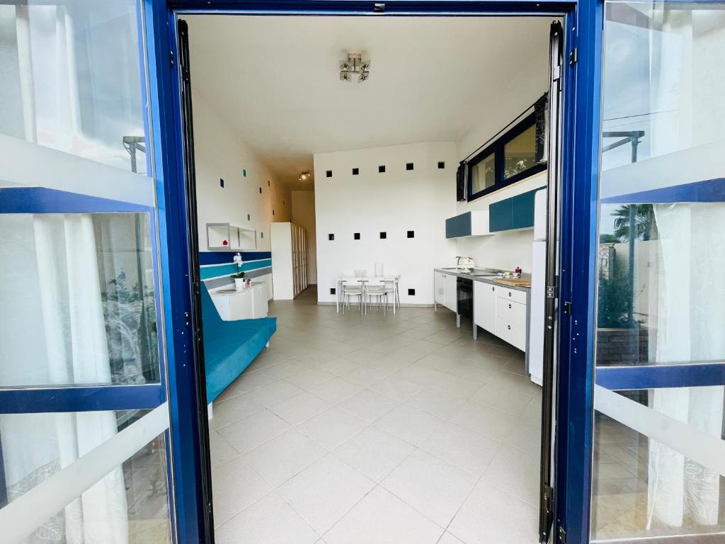 a large kitchen with blue and white cabinets at Casa Serra in Porto Palo