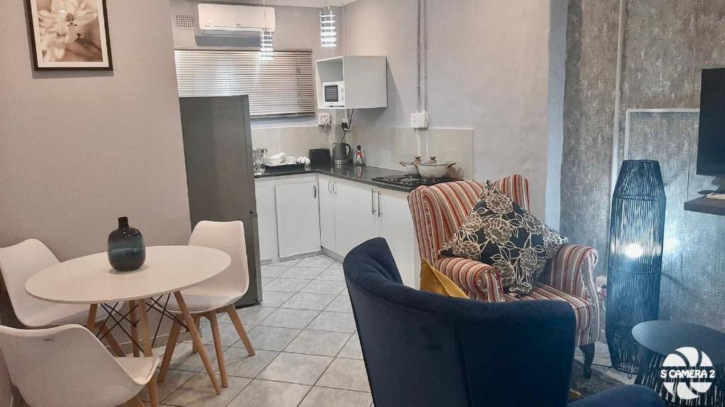 a kitchen with a table and chairs and a table and a kitchen with a table at 36 frere road shelly beach , margate in Margate