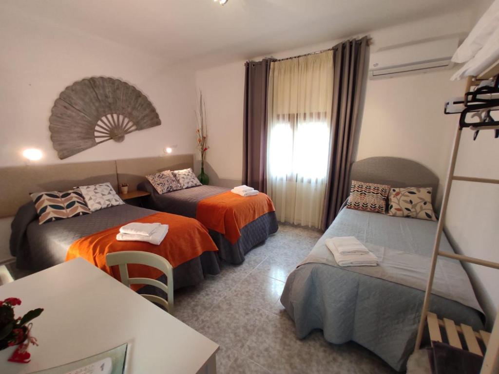 Habitación de hotel con 2 camas y mesa en Acogedor Alojamiento, en Membrilla