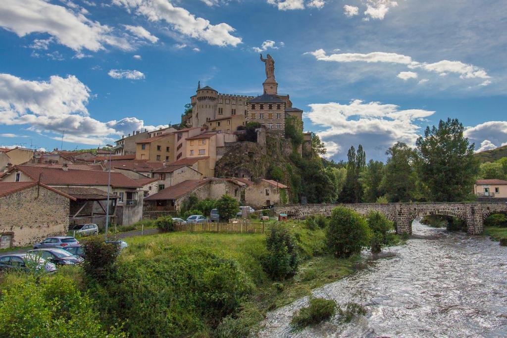 um edifício no topo de uma colina ao lado de um rio em 2 suites, Balnéo, 2 SDB, 3WC, Stationnement gratuit, à 5 minutes du Puy em Espaly-Saint-Marcel