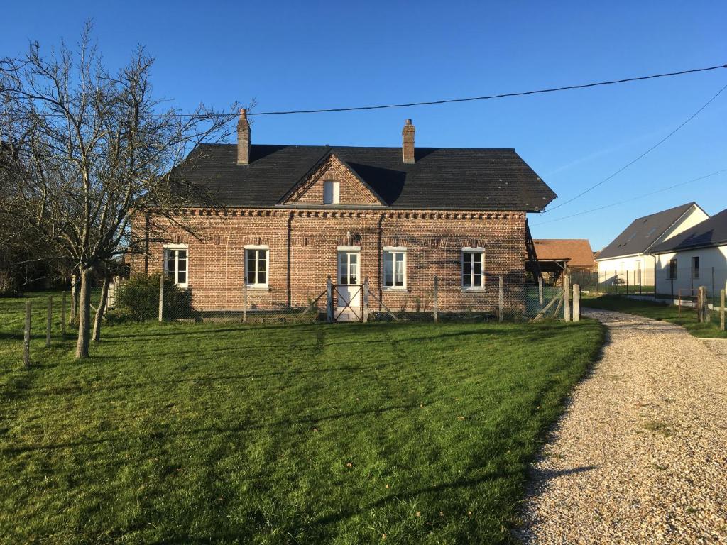 een oud stenen huis op een grasveld bij LE TILLEUL in Saint-Ouen-du-Tilleul