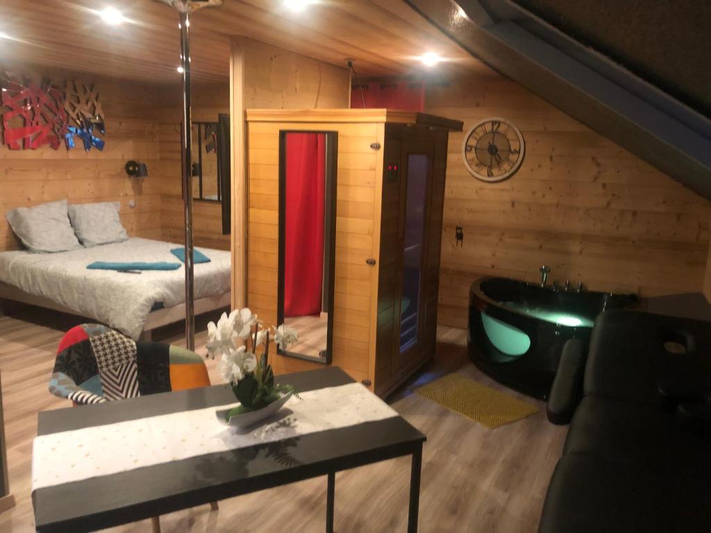 um quarto com uma cama e uma banheira num quarto em Love Chalet em Nancray