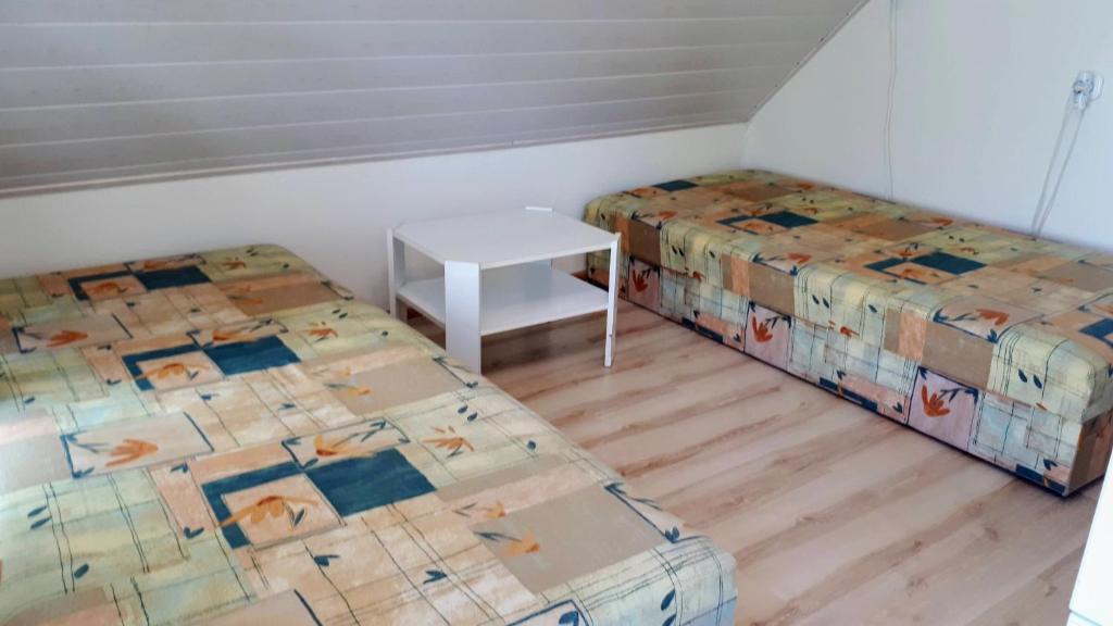 een kamer met twee bedden en een tafel erin bij Locher Apartman 1 Bükfürdő in Bük
