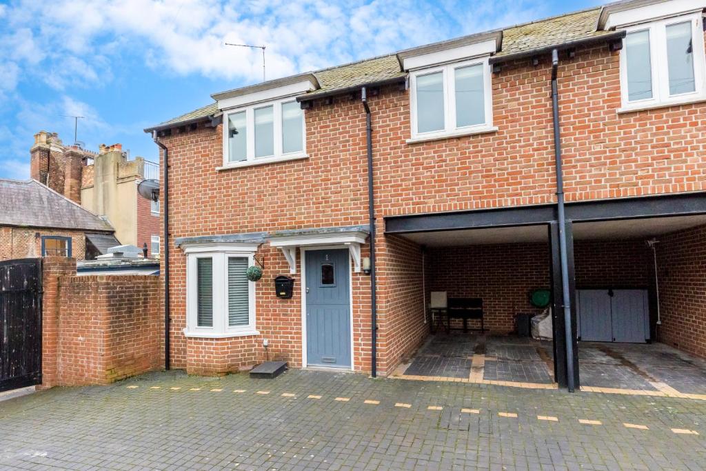 uma casa de tijolos com uma garagem e uma porta azul em Magnolia House em Poole