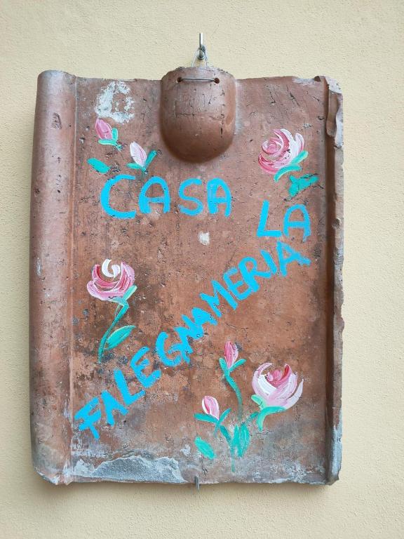 a rusty metal sign with writing on a wall at CASA LA FALEGNAMERIA in Bivigliano