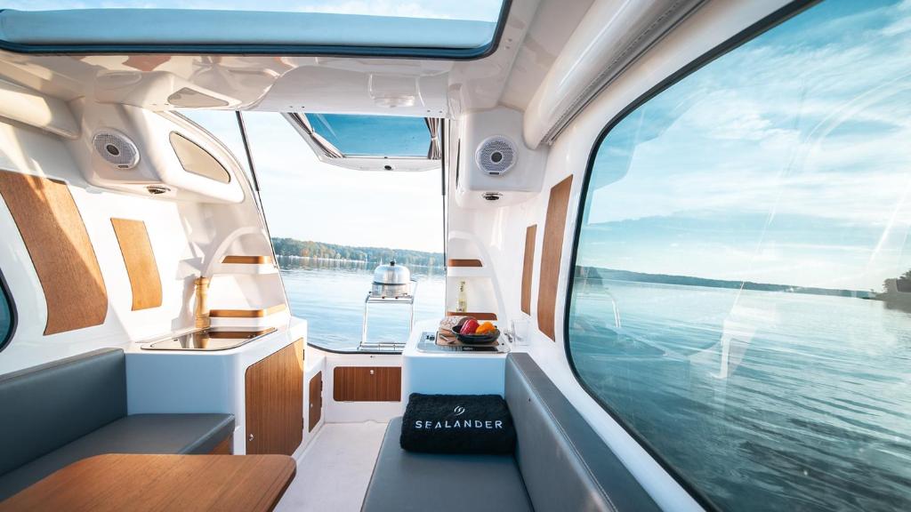 uma vista para fora da janela de um barco sobre a água em Sealander - Tiny Wohnwagen und Boot - Ferienwohnung Creutzig am Campingplatz Schachenhorn em Bodman-Ludwigshafen