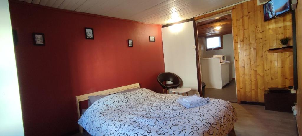 a bedroom with a bed and a red wall at Studio hypercentre à 2 pas de la gare. Appart n°3 in Agen