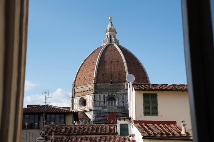 een gebouw met een koepel op een dak bij Cozy Dante's Apartment in Florence