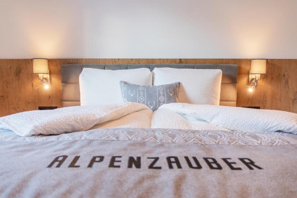 a bedroom with a large bed with an al zimbabwe sign on it at Aparthaus Alpenzauber in Neustift im Stubaital