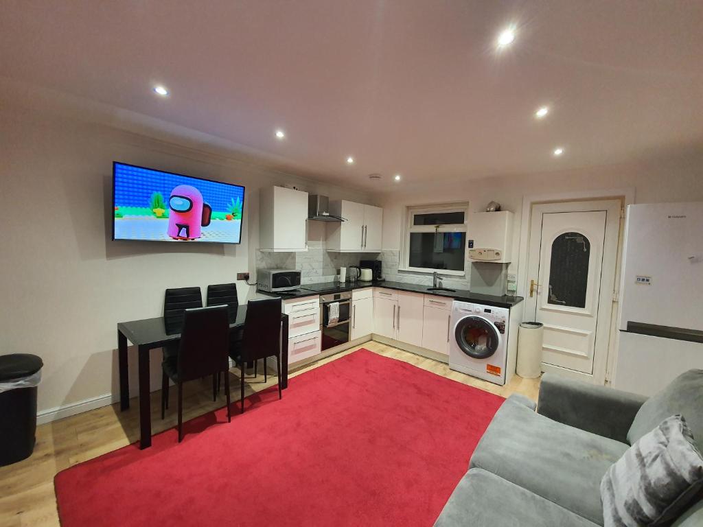 ein Wohnzimmer mit einem Sofa und einem TV an der Wand in der Unterkunft Modern house close to Glasgow Green in Glasgow