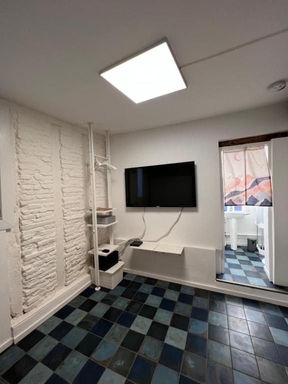 Cette chambre dispose d'une télévision à écran plat et d'un sol en damier. dans l'établissement Studio Centre Historique Toulouse Saint Etienne, Carmes, à Toulouse