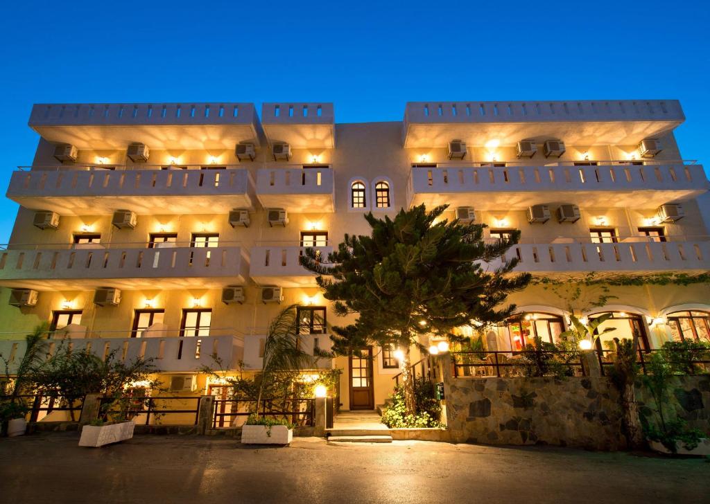 a large white building with lights on it at night at Floral Hotel in Hersonissos