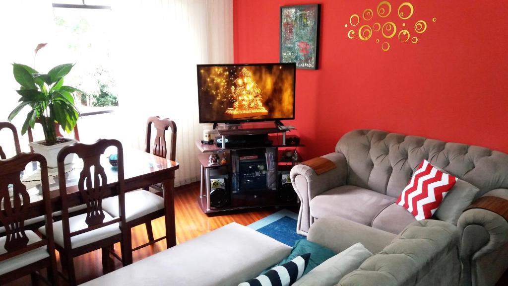 sala de estar con sofá y TV en Acomodação-Viasoft-UP-Ecoville-INC-FioCruz-CIC, en Curitiba