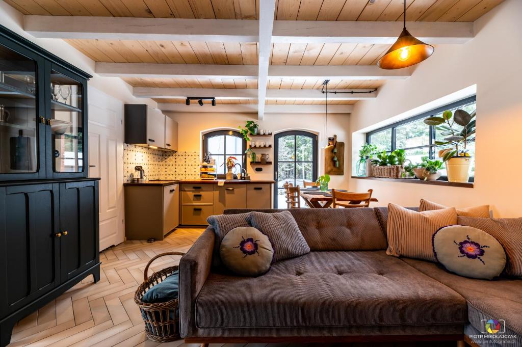 a living room with a couch and a kitchen at Apartamenty Stacja Huta in Szklarska Poręba