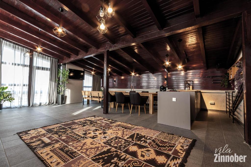 Habitación grande con mesa y alfombra en el suelo en Vila Zinnober, en Brasov
