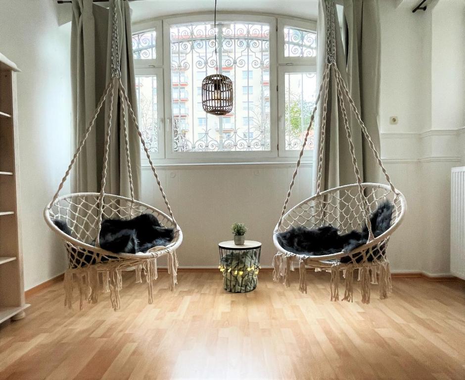 due sedie sospese in una stanza con finestra di UrbanSuites - Dein Zuhause in Wiesbaden a Wiesbaden