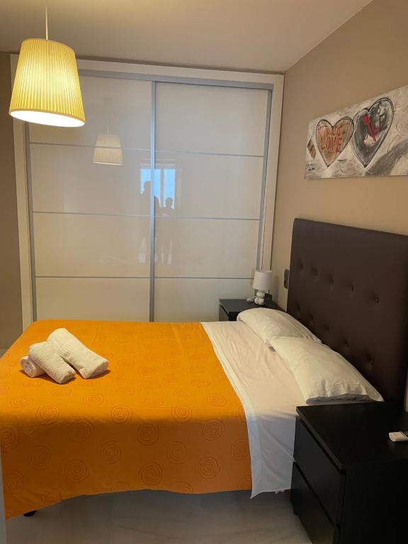 a bedroom with a large bed with a yellow blanket at Apartamento Plaza del Socorro in Ronda