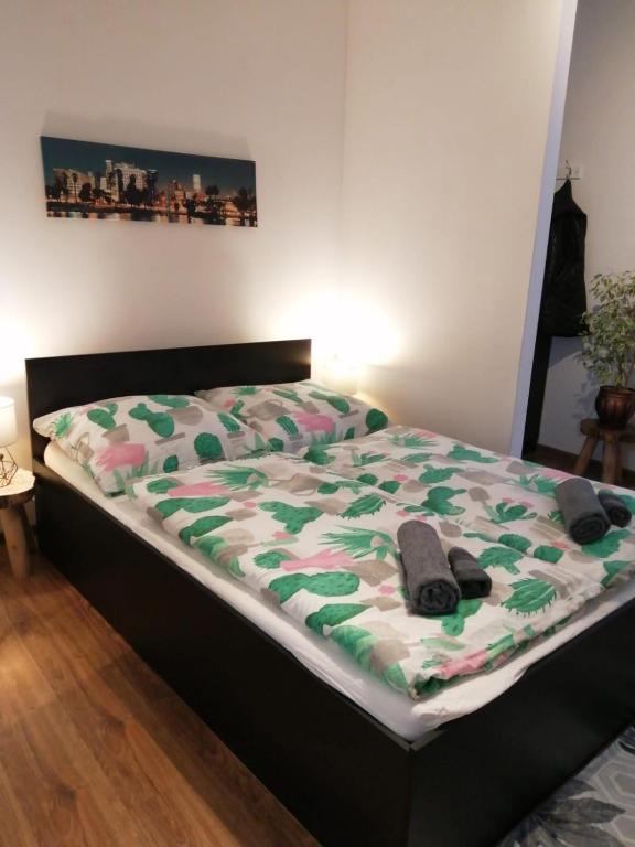 a bed with a green and white comforter on it at Przy rynku in Duszniki Zdrój