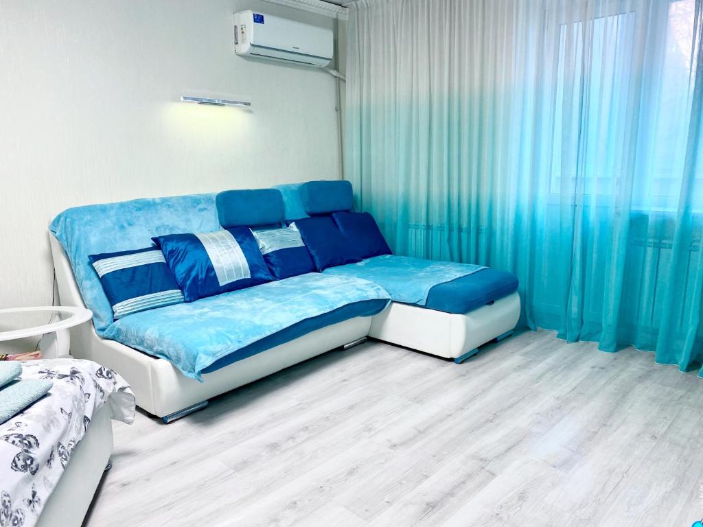 聶伯城的住宿－Апартаменти завжди зі світлом，蓝色和白色的卧室配有床和窗帘