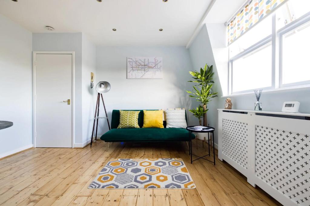 a living room with a green couch and a rug at Luxurious 1-Bedroom Apartment in Kensington in London