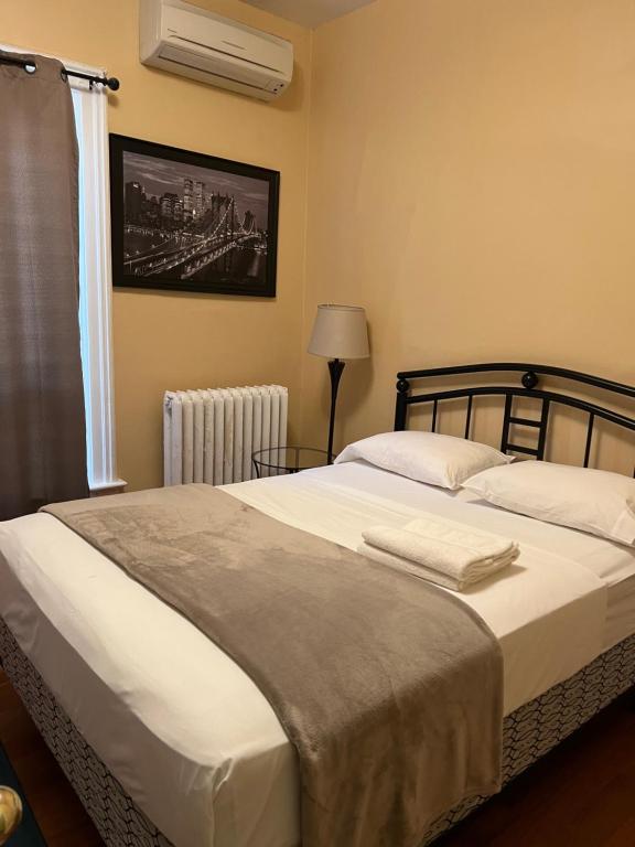 a bedroom with a large white bed and a window at Adas Guesthouse in Toronto