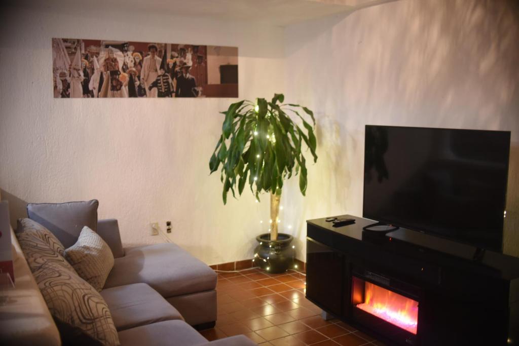Una sala de estar con un sofá y un televisor de pantalla plana. en The House of Cinema, en Guanajuato