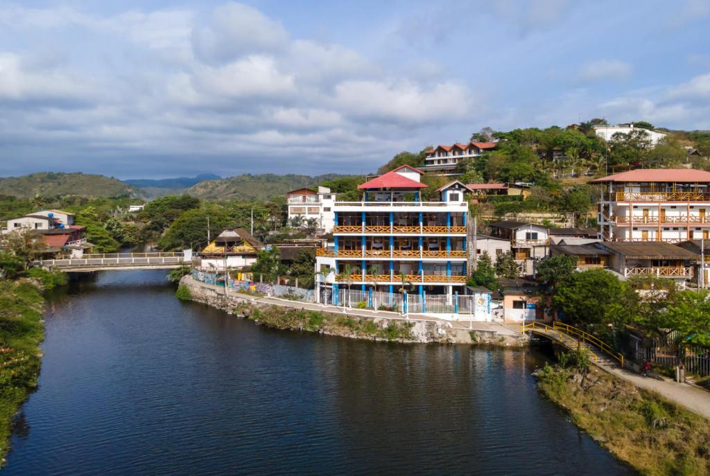 a river with buildings and a bridge in a city at Hotel Sol y Playa Montañita in Montañita