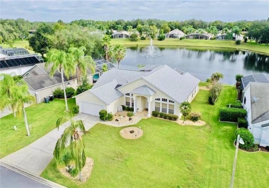 una vista aérea de una casa con un lago en Beautiful Waterfront Home with Heated Pool and Game Room en Davenport