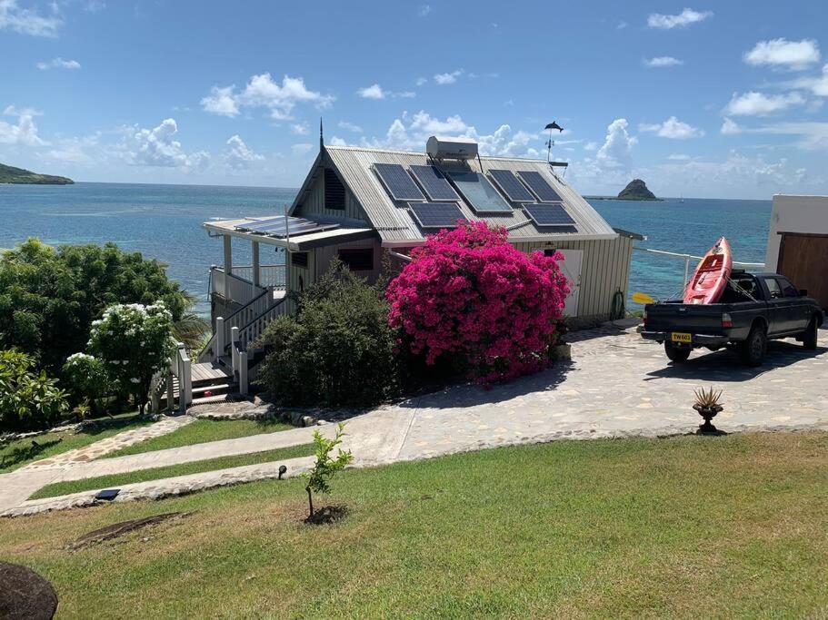 une maison avec des panneaux solaires en haut dans l'établissement Exclusive Beachfront Eco studio, à Hermitage